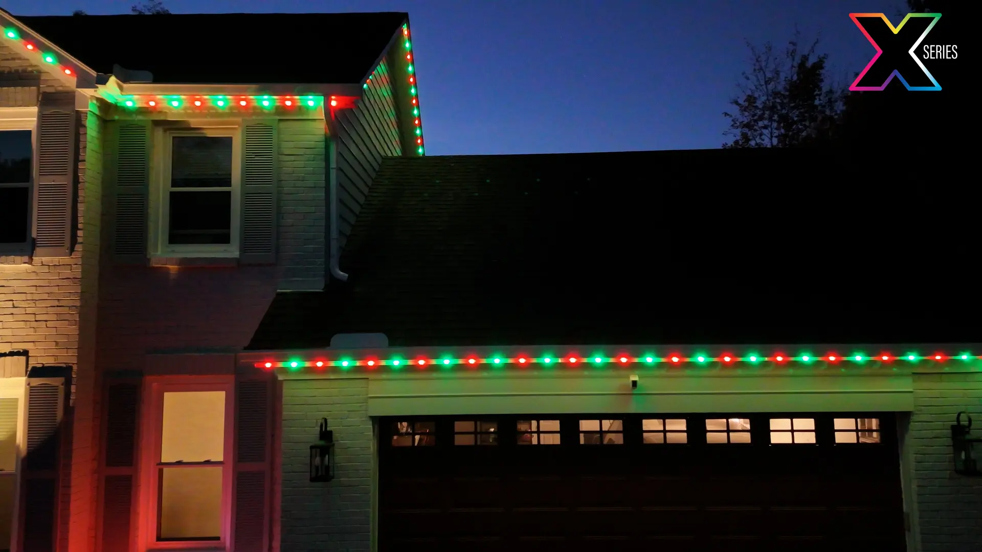 Garage and gable outlined in red and green holiday lighting