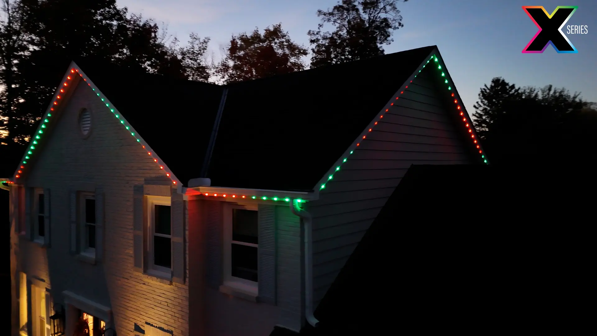Two gables outlined in red and green permanent holiday lighting
